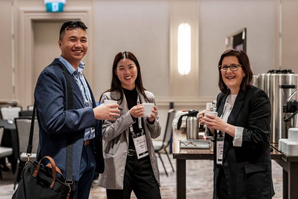 Three people chatting with drinks.