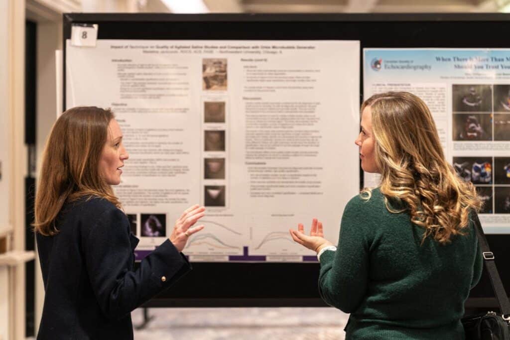 Two women discussing research poster